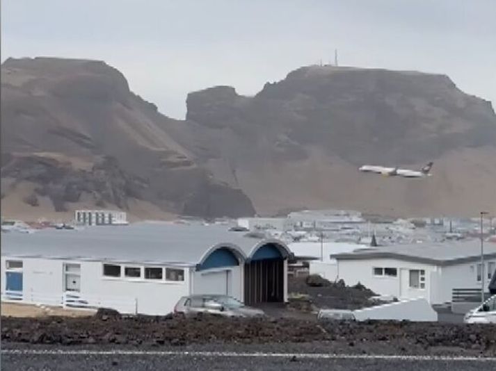 Hæð flugvélarinnar sést vel í samanburði við hæð Klifsins, fjallsins fyrir aftan með möstrunum. Klifið er 228 metra hátt eða um 750 fet.