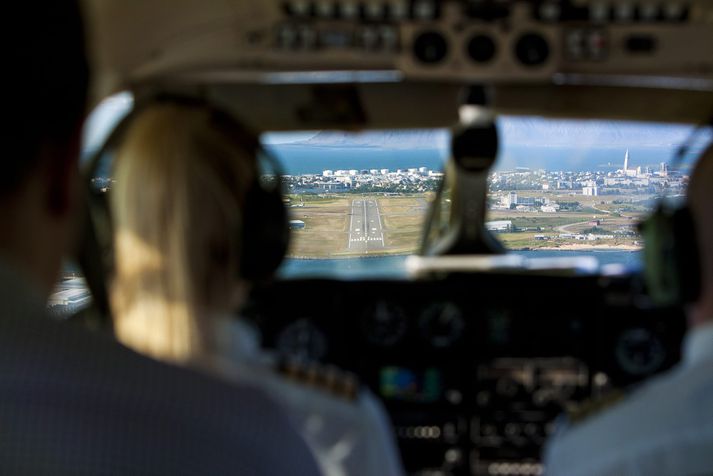 Flugmenn standa við bakið á vélvirkjum.