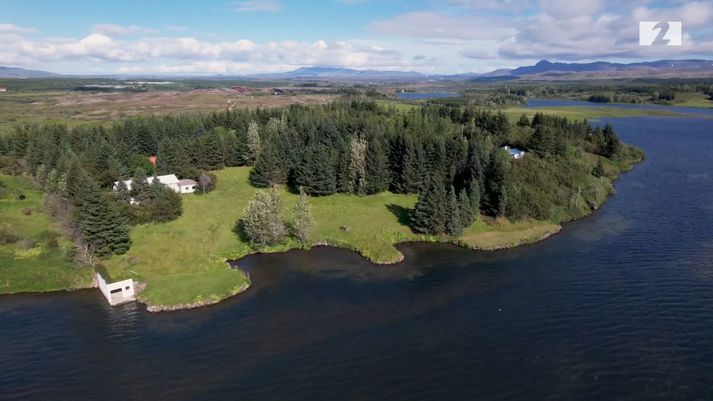 Húsið Víðivellir við Elliðavatn er núna umlukið háum trjágróðri sem Guðmundur ræktaði upp. Bátaskýlið til vinstri.