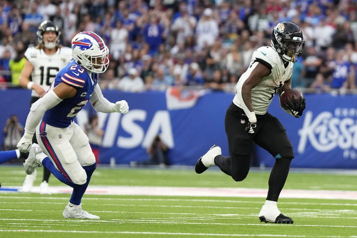 Travis Etienne Jr. fá fleygiferð með boltann í leiknum á móti Buffalo Bills á ottenham Hotspur leikvanginum í London.