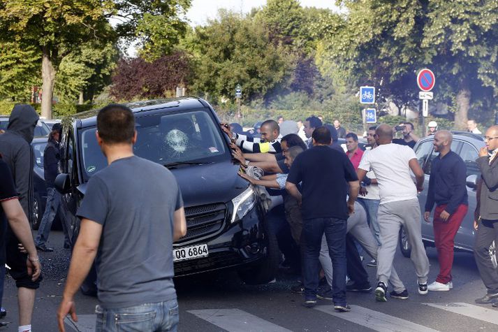 Franskir leigubílstjórar ráðast reyna að velta meintum Uber-leigubíl í París fyrr í dag.