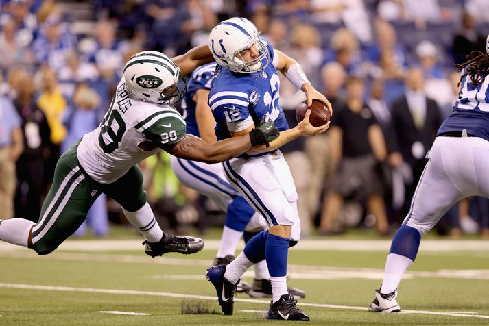 Andrew Luck er hér rifinn niður af varnarmanni New York Jets.