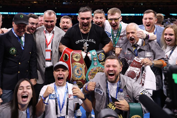 Oleksandr Usyk stillir sér upp fyrir myndatöku með meistarabeltunum og liðsmönnum sínum eftir sigur á Daniel Dubois í kjölfar bardaga þeirra um heimsmeistaratitla IBF, IBO, WBC og WBO í þungavigt á „Undisputed“ bardagakvöldinu á Wembley-leikvanginum þann 19. júlí 2025 í London.