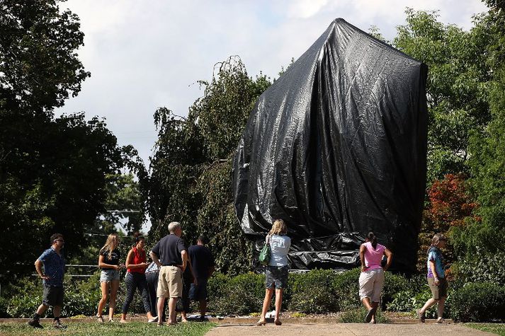 Styttan af Robert E. Lee í Frelsisgarðinum í Charlottesville er nú hulin svörtum dúk.