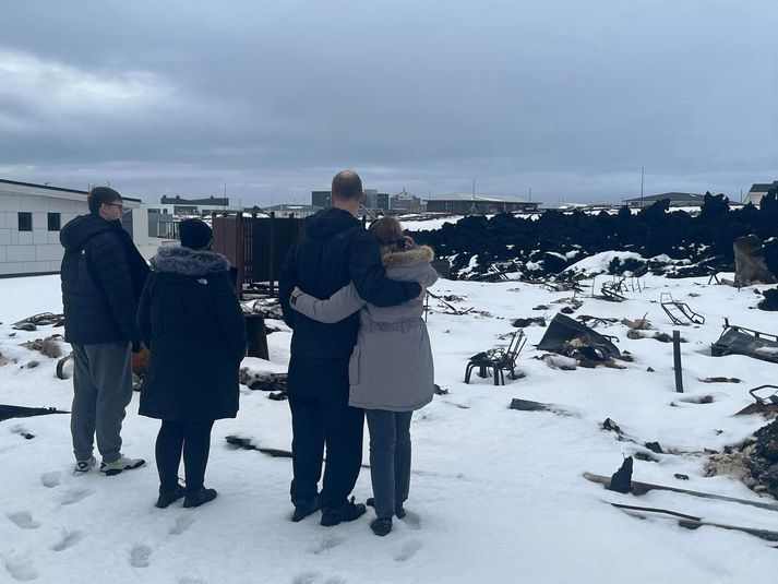 Fjölskyldan fyrir framan húsgrunninn þar sem heimili þeirra stóð allt þar til 14. janúar. 