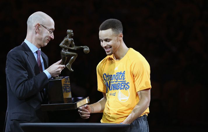 Steph Curry fær hér styttuna frá Adam Silver.