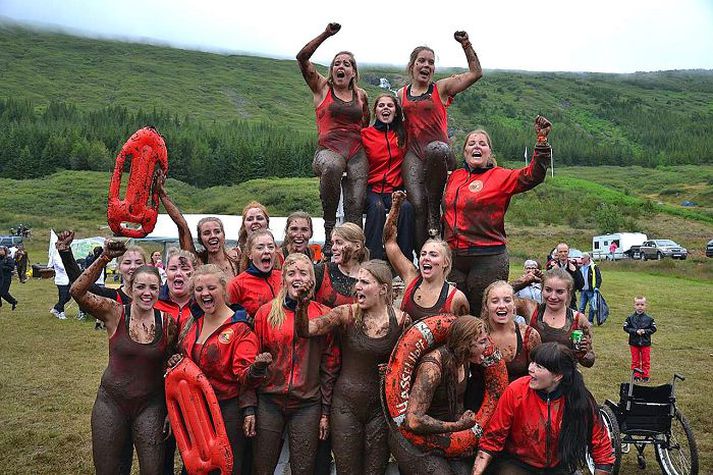 Team Hasselhoff Arna situr hér í strandvarðarstólnum og er umvafin drullugum liðsfélögum sínum í Team Hasselhoff sem sigraði í kvennadeild Mýrarboltamótsins á Ísafirði í ár. mynd/Hajo von Häfen