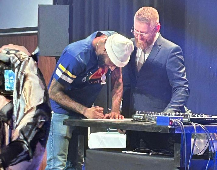 DeAndre Kane skrifar undir nýjan samning við Grindavík uppi á sviði á lokahófi félagsins.