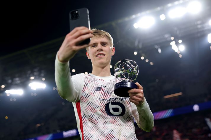 Hákon Arnar Haraldsson tekur sjálfu af sér með verðlaunabikar eftir að hann var valinn maður leiksins í Meistaradeildarleik Lille á móti Borussia Dortmund í sextán liða úrslitum keppninnar.