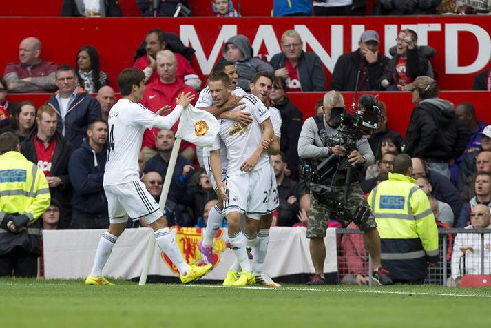 Gylfi fagnar marki sínu á móti Manchester United með félögum sínum í Swansea við einn hornfánann á Old Trafford á laugardaginn.