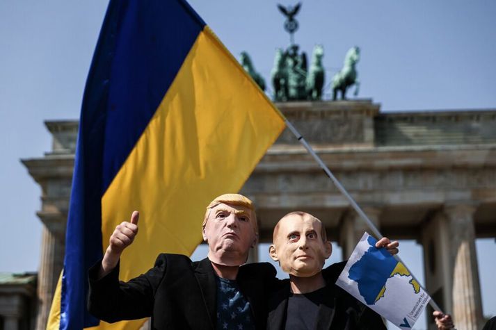 Stuðningsmenn Úkraínu með grímur af Trump og Pútín við Brandenborgarhliðið í Berlín.