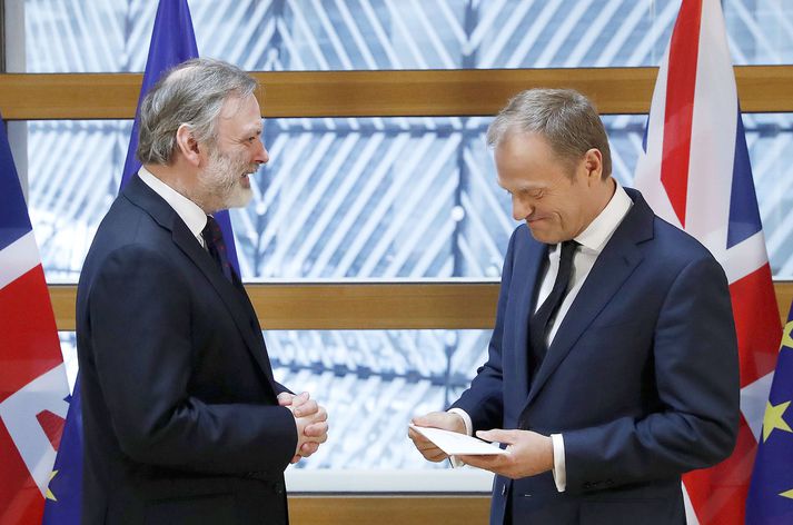 Donald Tusk, forseti leiðtogaráðs ESwB, tekur við úrsagnarbréfi frá fastafulltrúa Bretlands, Tim Barrow.