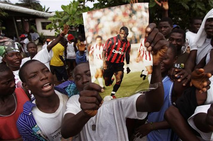 Stuðningsmenn George Weah halda á mynd af honum á dýrðartíma hans hjá AC Milan, en Weah er mjög vinsæll í heimalandi sínu.