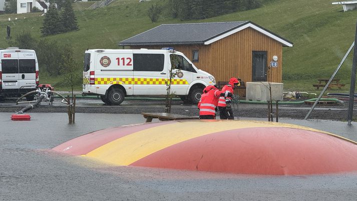 Ærslabelgurinn í miðbæ Ólafsfjarðar var hundblautur og hálfur undir vatni í gær en slökkviliðið reddaði málunum. Þegar svona óvanalegt veður skellur á getur verið gott að hafa það hugfast að það styttir alltaf upp að nýju og sólin brýst í gegnum skýin. Áður en við vitum af verða krakkarnir á Ólafsfirði farnir að hoppa hæð sína á ærslabelgnum.
