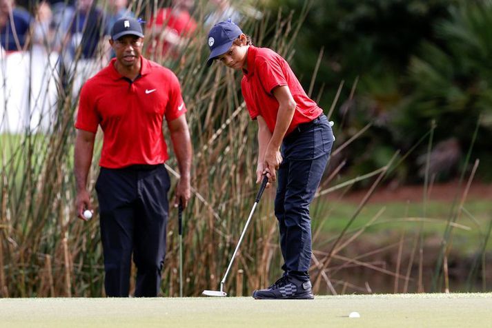 Tiger Woods fylgist hér með syni sínum Charlie Woods setja niður pútt á mótinu um helgina.