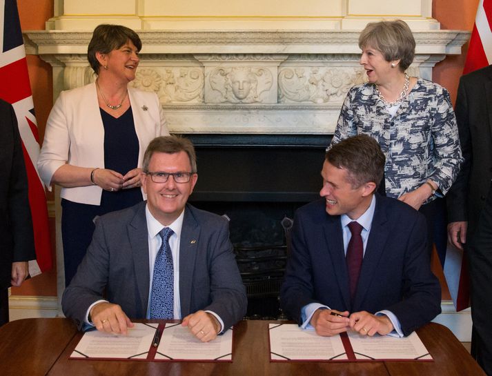 Arlene Foster og Theresa May standa andspænis hvor annarri við undirritum samkomulagsins.