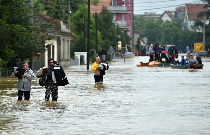 Íbúar í Obrenovac, sem er 40 km vestan við Belgrad, höfuðborg Serbíu, vaða vatnselginn.