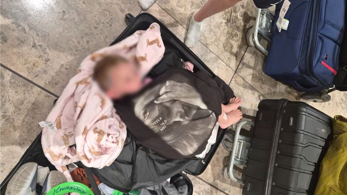 Þessi ungi drengur svaf í ferðatösku á flugvellinum á Alicante á Spáni í nótt. Þó nokkrar fjölskyldur urðu þar eftir.