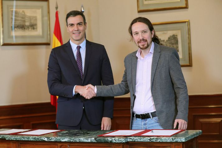 Pedro Sanchez og Pablo Iglesias skrifa undir samkomulagið.