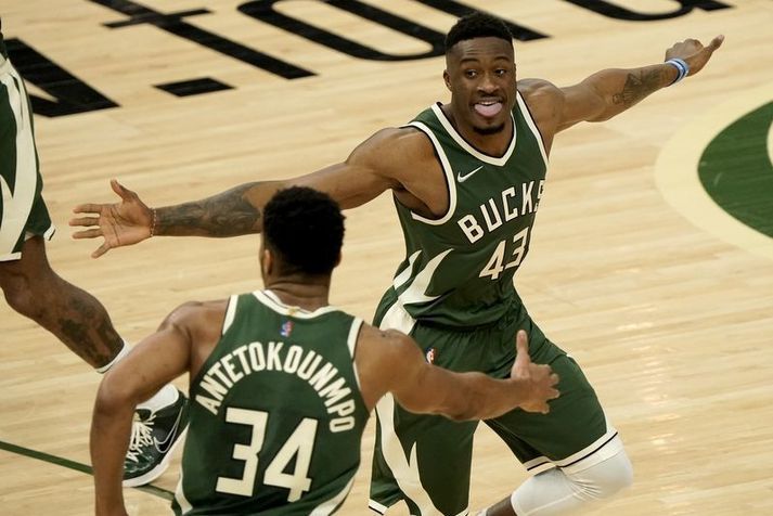 Bræðurnir Giannis Antetokounmpo og Thanasis Antetokounmpo fagna saman góðri körfu hjá Milwaukee Bucks í nótt.