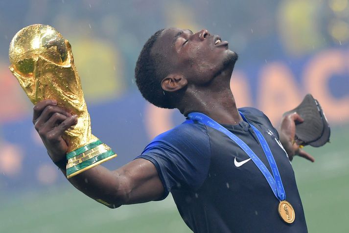 Paul Pogba fagnar heimsmeistaratitlinum í Moskvu með HM-bikarinn í hendinni og HM-gullverðlaunin um hálsinn.