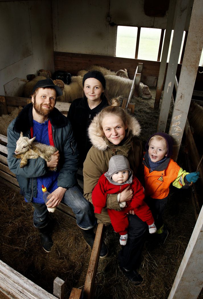 Fjölskyldan á Karlstöðum í fjárhúsinu þar sem þau una sér vel þrátt fyrir að hafa fengið 60 kindur óvænt með í kaupunum á býlinu. 