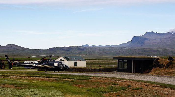 þyrla Ólafs tekur 6 manns í sæti og er þar með sú stærsta í einkaeigu á landinu. Til hægri sést í innganginn að húsi Ólafs. Lítið ber á húsinu sjálfu enda er það byggt inn í landið.