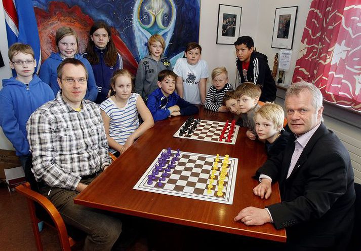 Héðinn Steingrímsson stórmeistari og Helgi Árnason skólastjóri eru virkir í Skákdeild Fjölnis. Hér eru þeir ásamt nokkrum nemendum 4. og 6. bekkjar Rimaskóla.