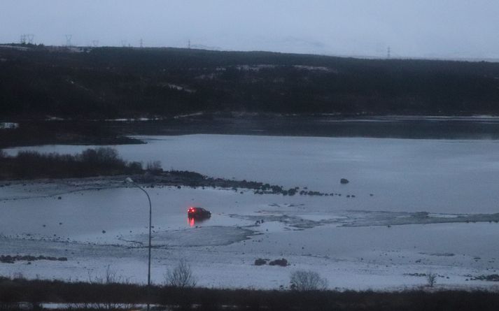 Bíllinn sést hér í vatninu síðdegis í dag.