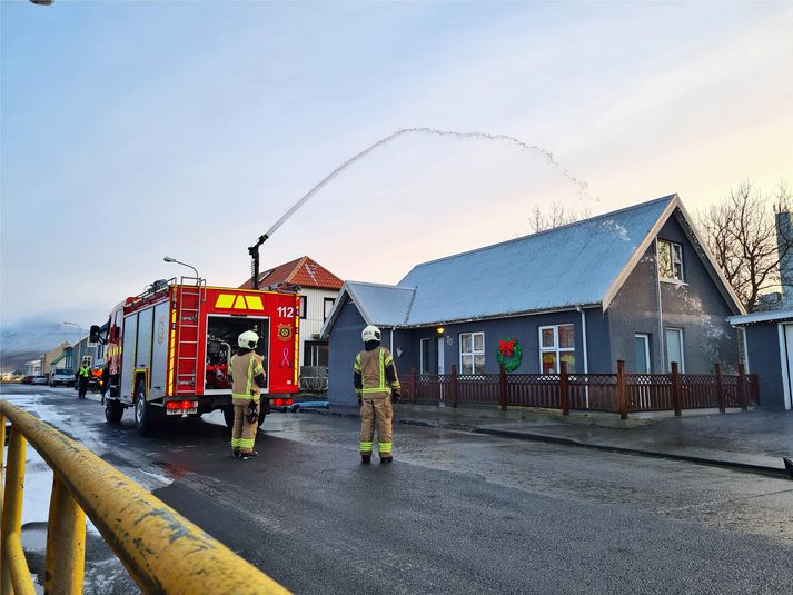 Líkt og sjá má á bárujárnsþakinu er grá slikja yfir því. Slökkviliðið vinnur nú að hreinsunarstörfum.