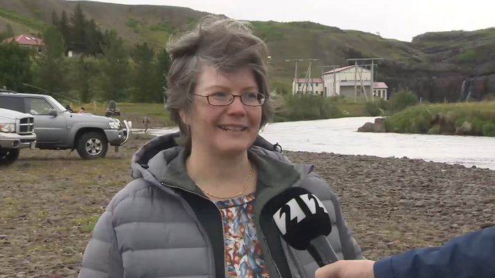 Ragnhildur Helga Jónsdóttir, formaður Veiðifélags Andakílsár. Stöðvarhús Andakílsárvirkjunar í baksýn.