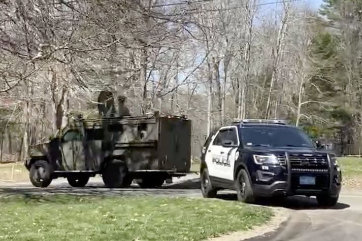 Lögreglubílar loka vegum í kringum heimili ungs manns sem er grunaður um að leka háleynilegum gögnum í Massachusetts í dag.
