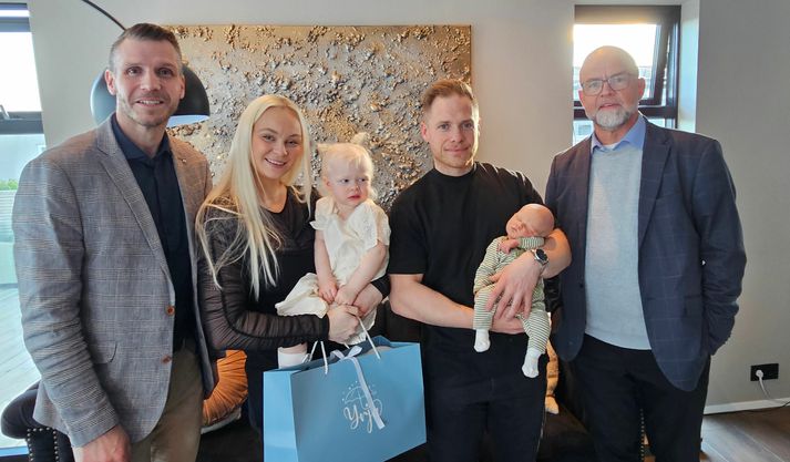 Fjölskyldan, ásamt Kjartani forseta bæjarstjórnar (t.h.) og Braga bæjarstjóra þegar þeir mættu í kvöld og færðu íbúa númer 12 þúsund og fjölskyldu hans gjöf frá sveitarfélaginu.
