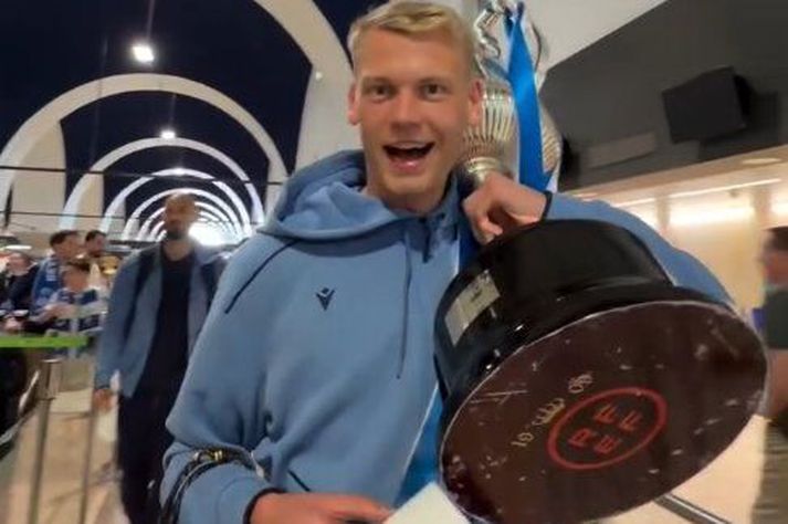 Orri Steinn Óskarsson með bikarinn á flugvellinum.