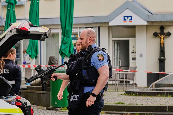 Lögregluþjónn gengur frá byssu sinni eftir umsátrið.