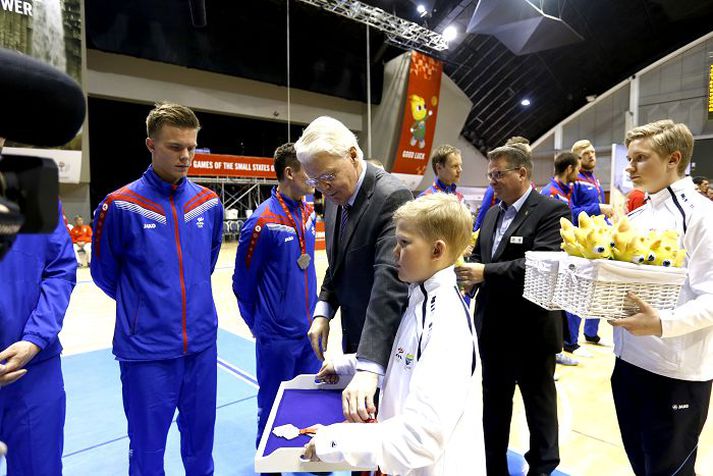 Ólafur Ragnar Grímsson forseti afhendir körfuboltaliðinu silfurverðlaun.