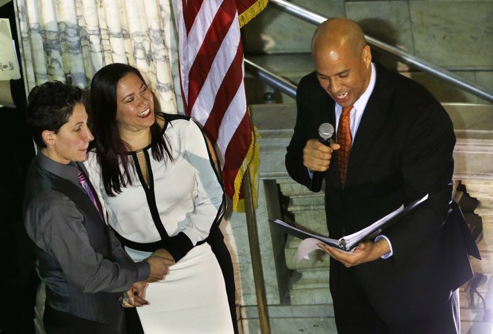 Hér sést Corey Booker, borgarstjórinn í Newark, gefa saman þær Liz Salerno og Gabriela Celeiro. Booker gaf sjö pör saman eftir miðnætti í gær, þar af voru tvö gagnkynhneigð pör, en Booker hafði áður lýst því yfir að hann myndi ekki standa fyrir nokkrum hjónavígslum fyrr en  jafnrétti yrði tryggt í ríkinu.