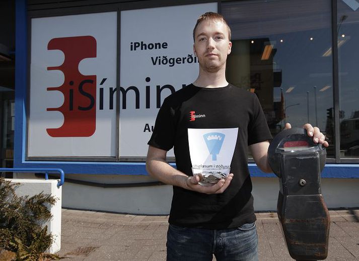 Tómas Kristjánsson, eigandi verslunarinnar iSíminn, býður fólki klink í stöðumæla við verslunina í Skipholtinu. Fréttablaðið/Vilhelm