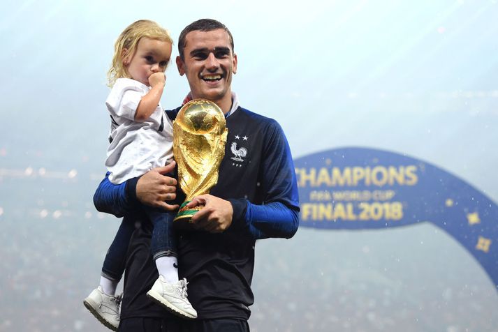 Antoine Griezmann fagnar gullstyttunni eftirsóttu með dóttur sinni