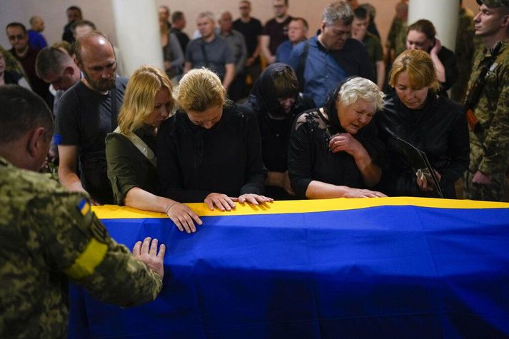 Dóttir, systir, móðir og eiginkona syrgja fallinn hermann í bænum Zhytomyr í Úkraínu í dag.