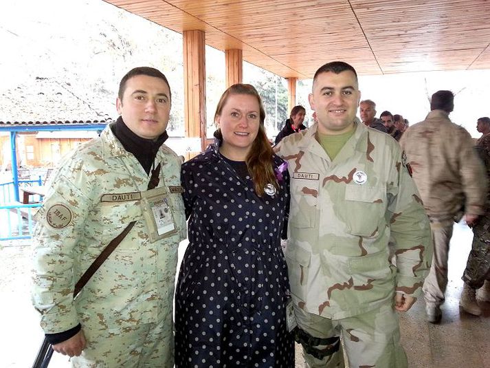 Steinunn Björk Pieper ásamt tveimur hermönnum. Þau bera öll fjólubláan fána 16 daga átaksins gegn kynbundnu ofbeldi.