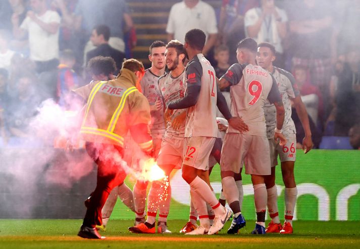 Liverpool fagnar eftir að blysi var hent inn á völlinn.