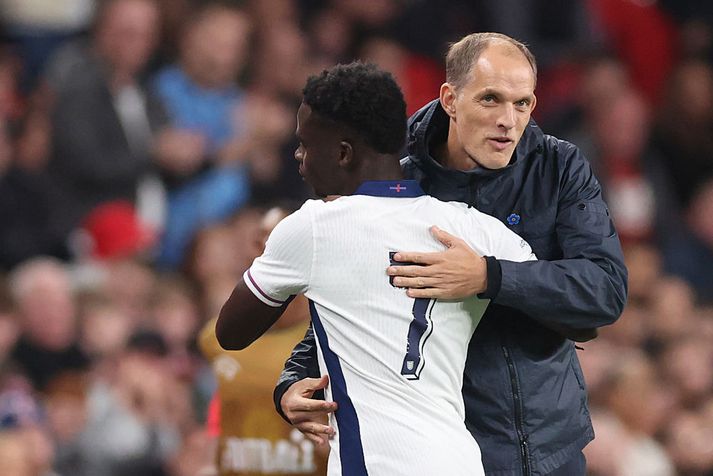 Thomas Tuchel faðmar Bukayo Saka, einn af markaskorurum Englands í kyrrðinni á Wembley í kvöld.
