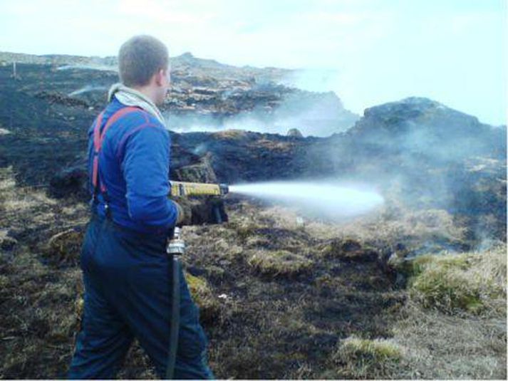 Slökkviliðsmenn slökkva í eldinum.