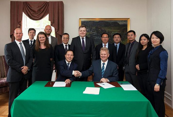 Wang Hongquian, forstjóri NFC, og Ingvar Skúlason, framkvæmdastjóri Klappa, handsala samstarfið. Að baki þeim standa Sigmundur Davíð Gunnlaugsson forsætisráðherra og Zhan Weidong, sendiherra Kína á Íslandi, auk fulltrúa sveitarstjórna á Norðurlandi vestra, NFC og Kínverska þróunarbankans.