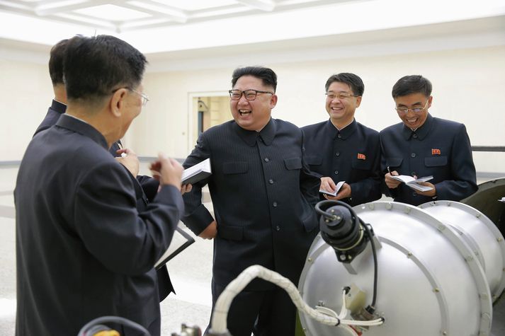 Kim Jong-un sést hér standa vígreifur ásamt samstarfsmönnum sínum yfir vopninu.