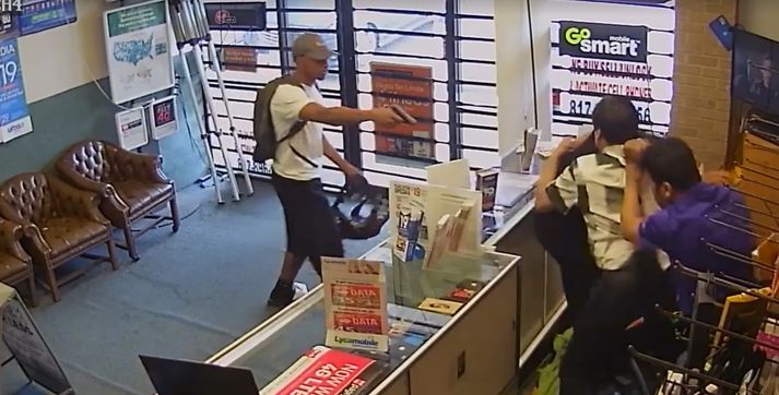 Hamagangurinn var mikill þegar verslunareigendurnir reyndu að ýta öðröm ræningjanna út úr versluninni. Á meðan beindi hinn byssu að þremenningunum.