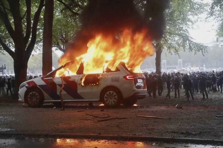 Til átaka kom milli mótmælenda og lögreglumanna í Haag. Kveikt var í þessum lögreglubíl.
