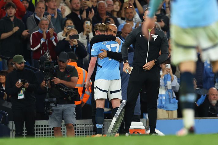 Pep Guardiola faðmar De Bruyne þegar sá síðarnefndi kemur af velli í kvöld.