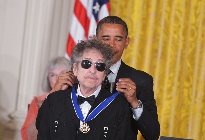 Barack Obama hengir Frelsisverðlaunin um háls tónlistarmannsins Bob Dylan.